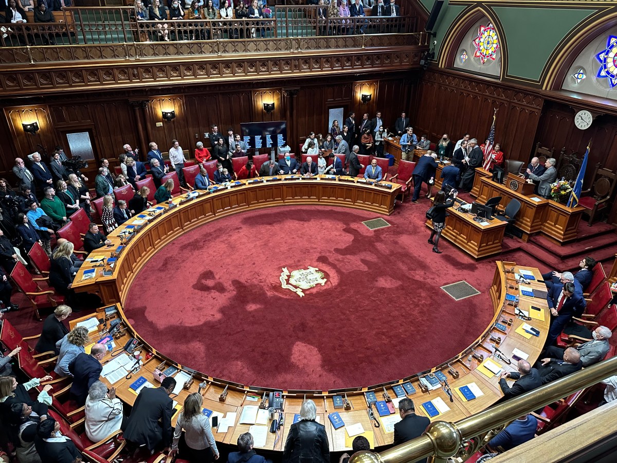 Connecticut lawmakers are seen on the floor of the Senate chamber in the State Capitol building.