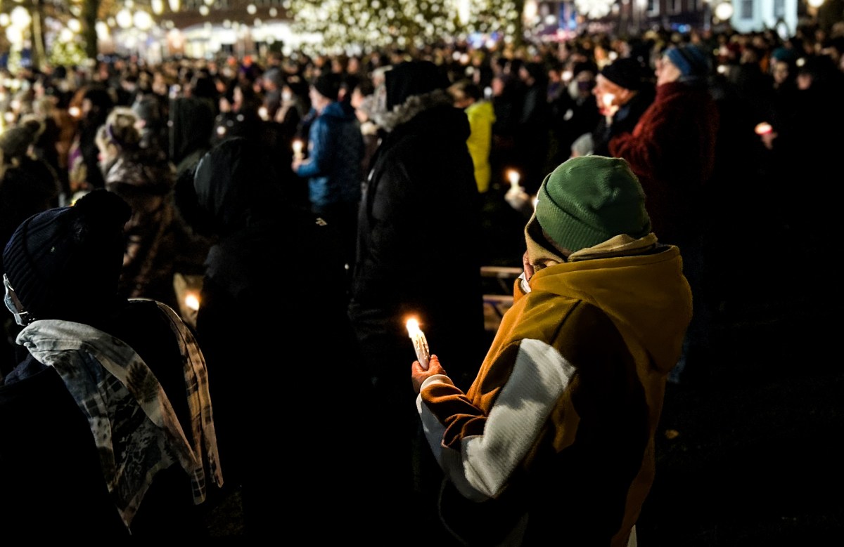 Hundreds of people bundled in winter hats, coats and scarfs hold candles and listen to speakers at a vigil for Quentin Williams, a state legislator who died in a car accident Thursday.