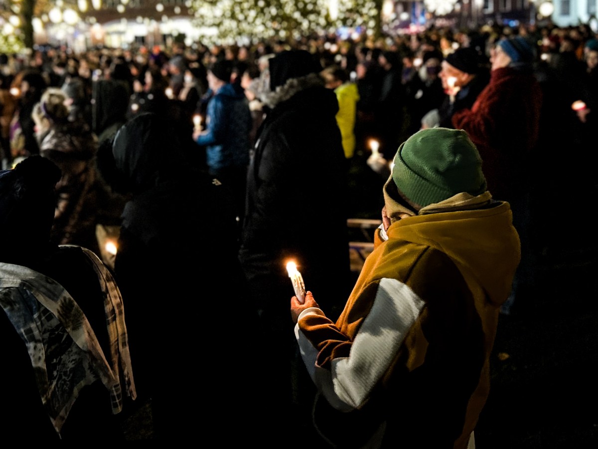 Hundreds of people bundled in winter hats, coats and scarfs hold candles and listen to speakers at a vigil for Quentin Williams, a state legislator who died in a car accident Thursday.