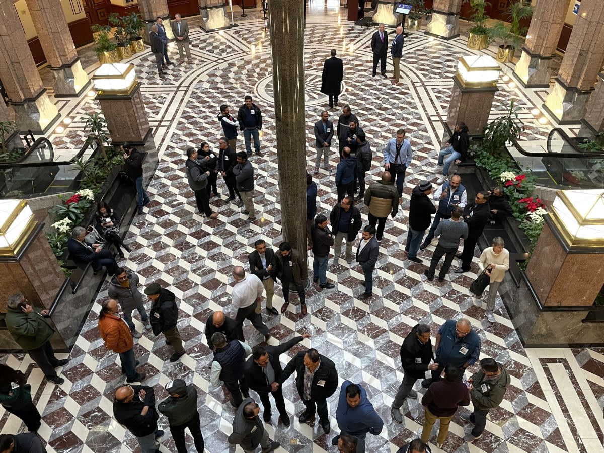 An overhead view of the lobby of the Connecticut Legislative Office Building, where a few dozen people have congregated.