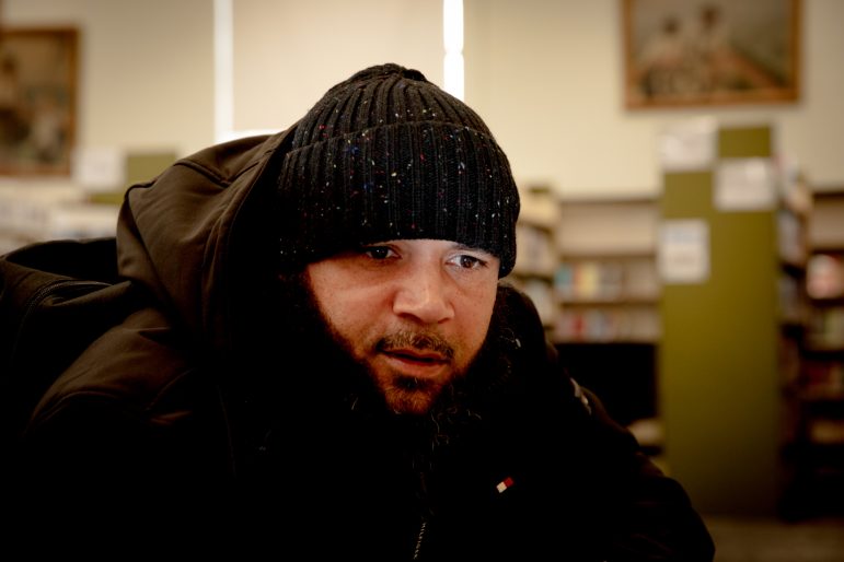 Un hombre con chaqueta negra y gorro de punto negro.