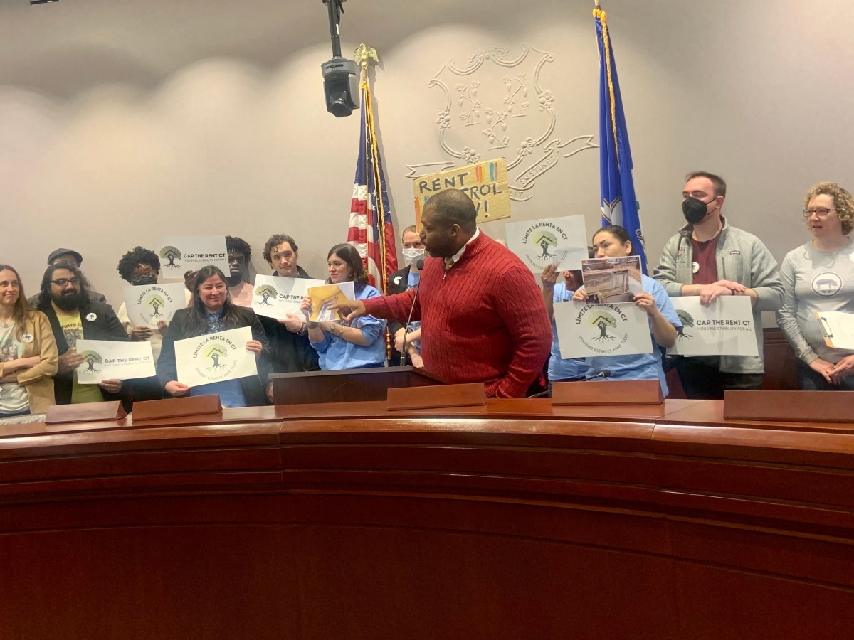 A man speaks in front of a crowd of people.