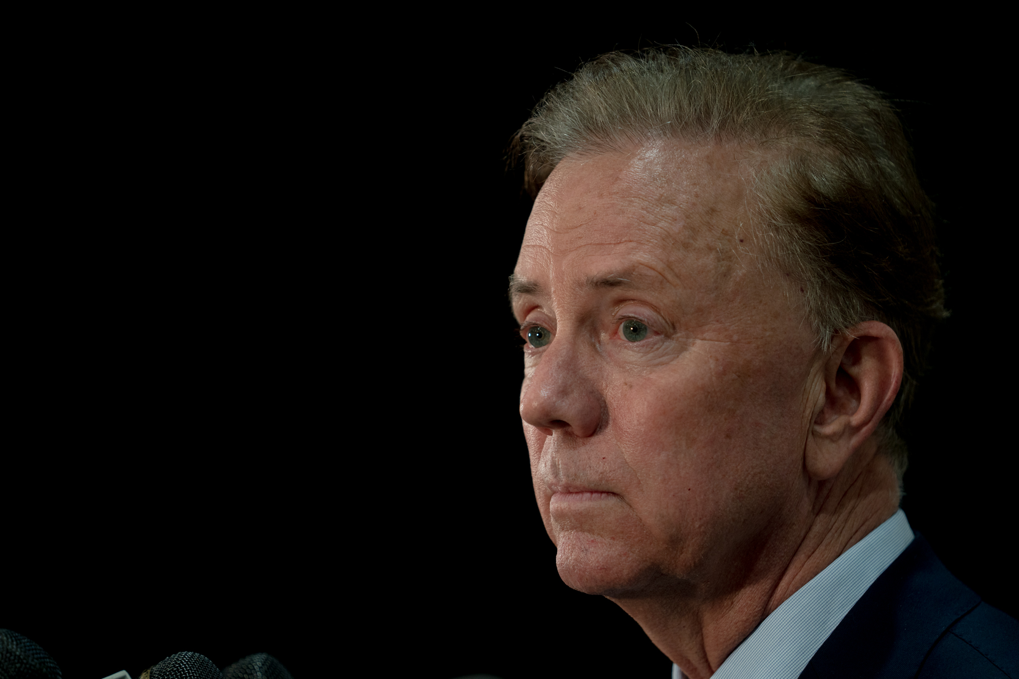 La imagen de la cara de un hombre contra un fondo negro.