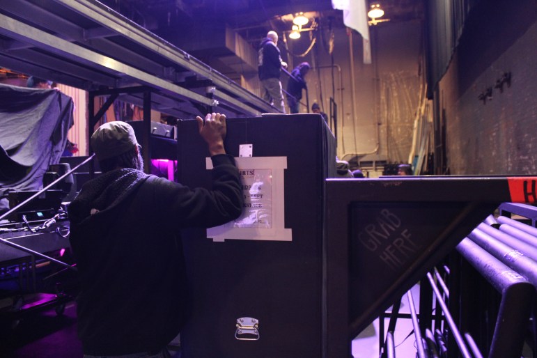 Stagehands load in wardrobe containers backstage at the Shubert Theatre.