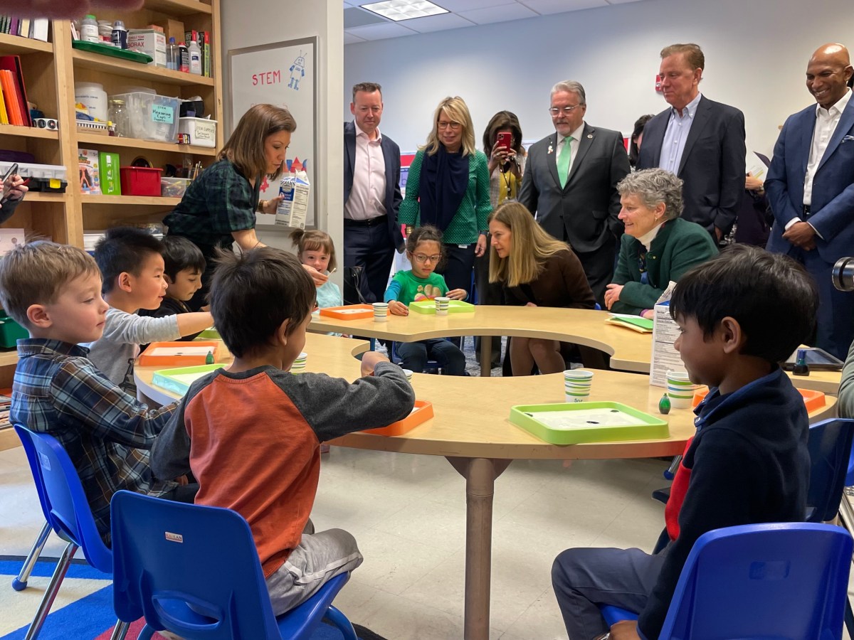 State officials visit with students at an early child care center.