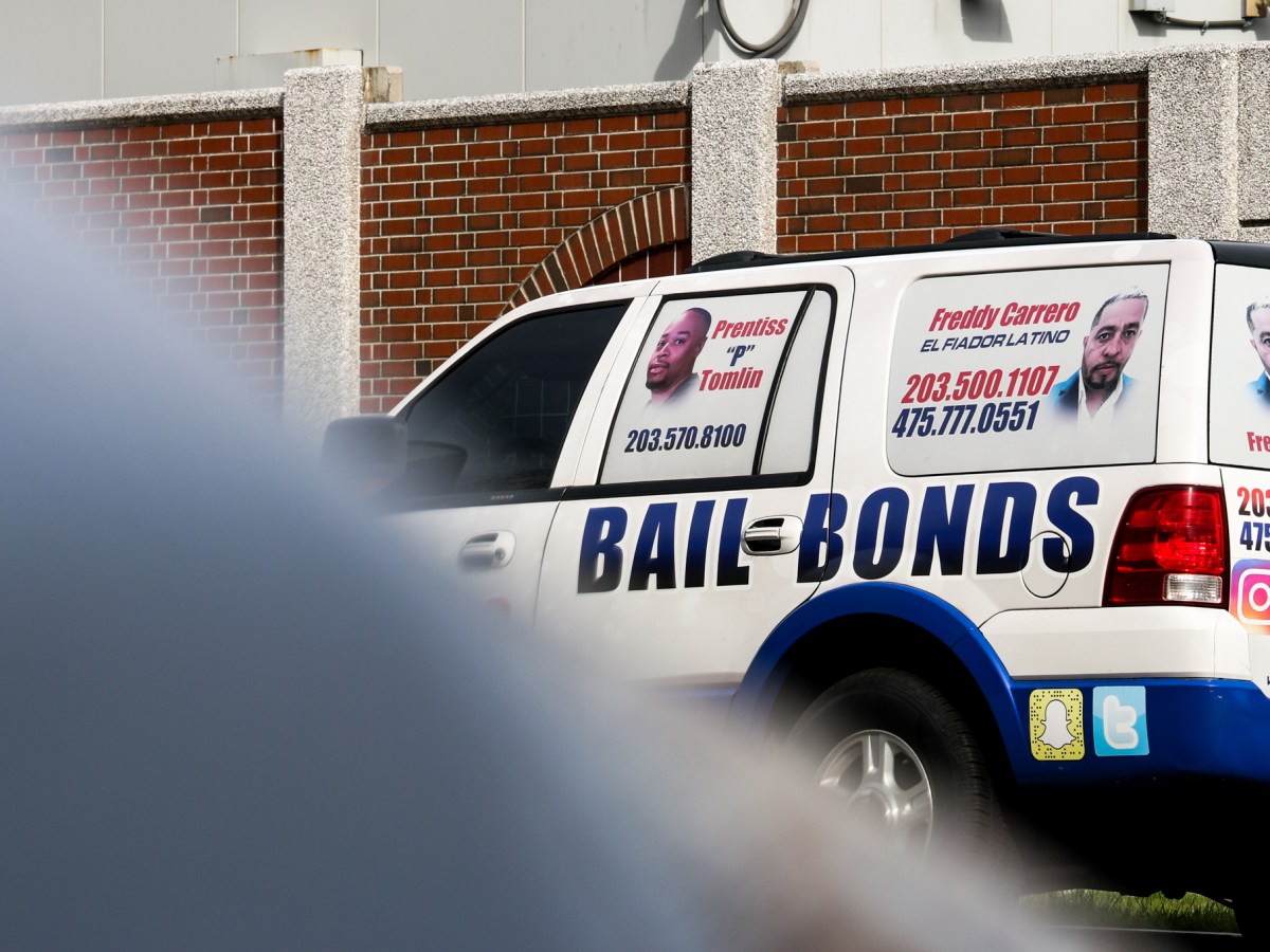 A bail bonds agency truck is parked near a sidewalk in New Haven.
