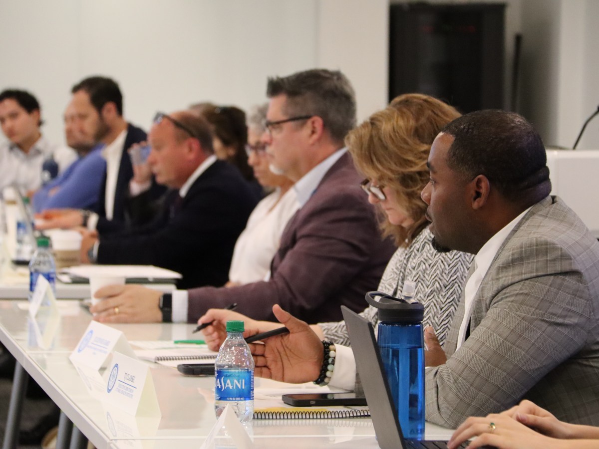 Ten people sit at a white table.