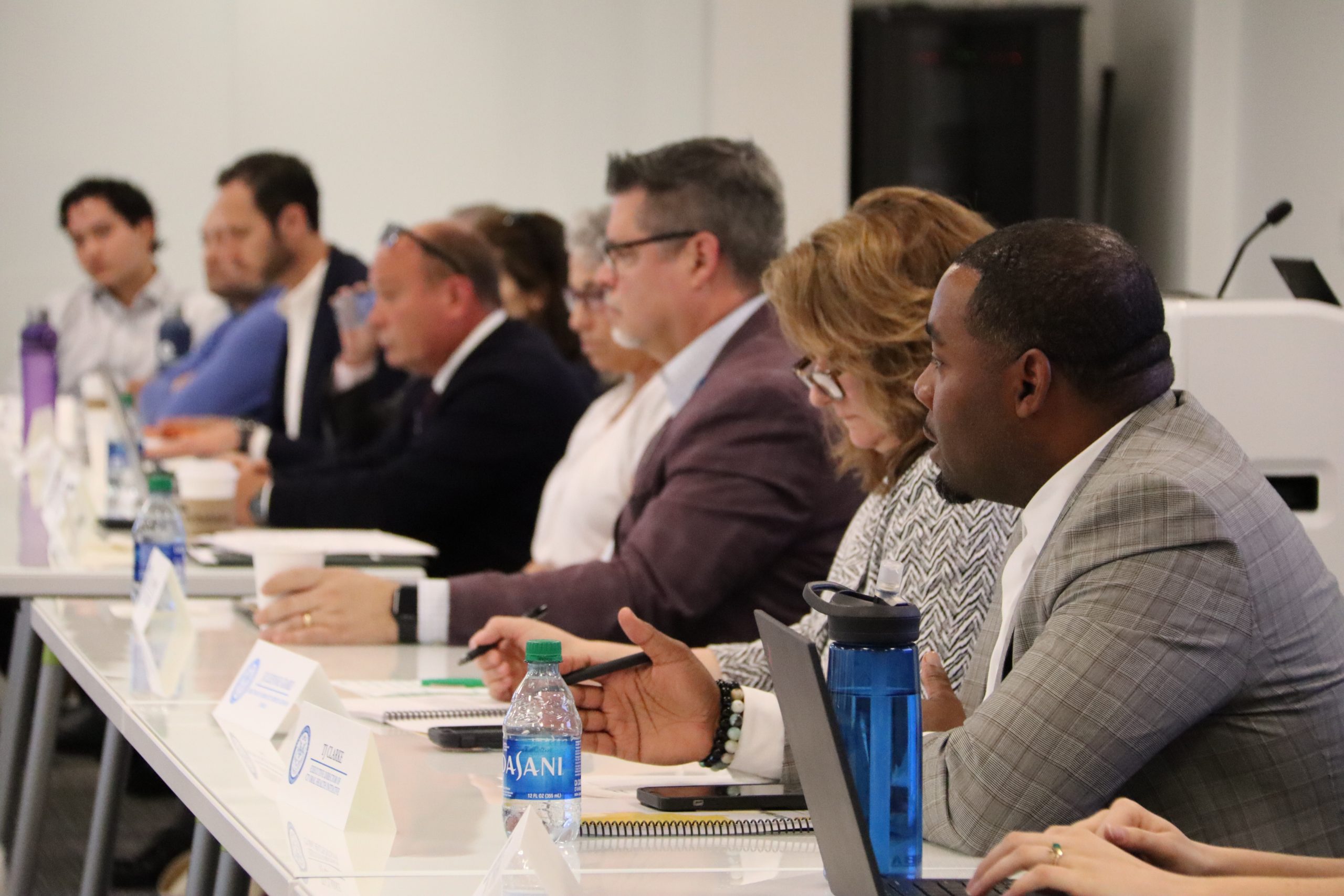Ten people sit at a white table.