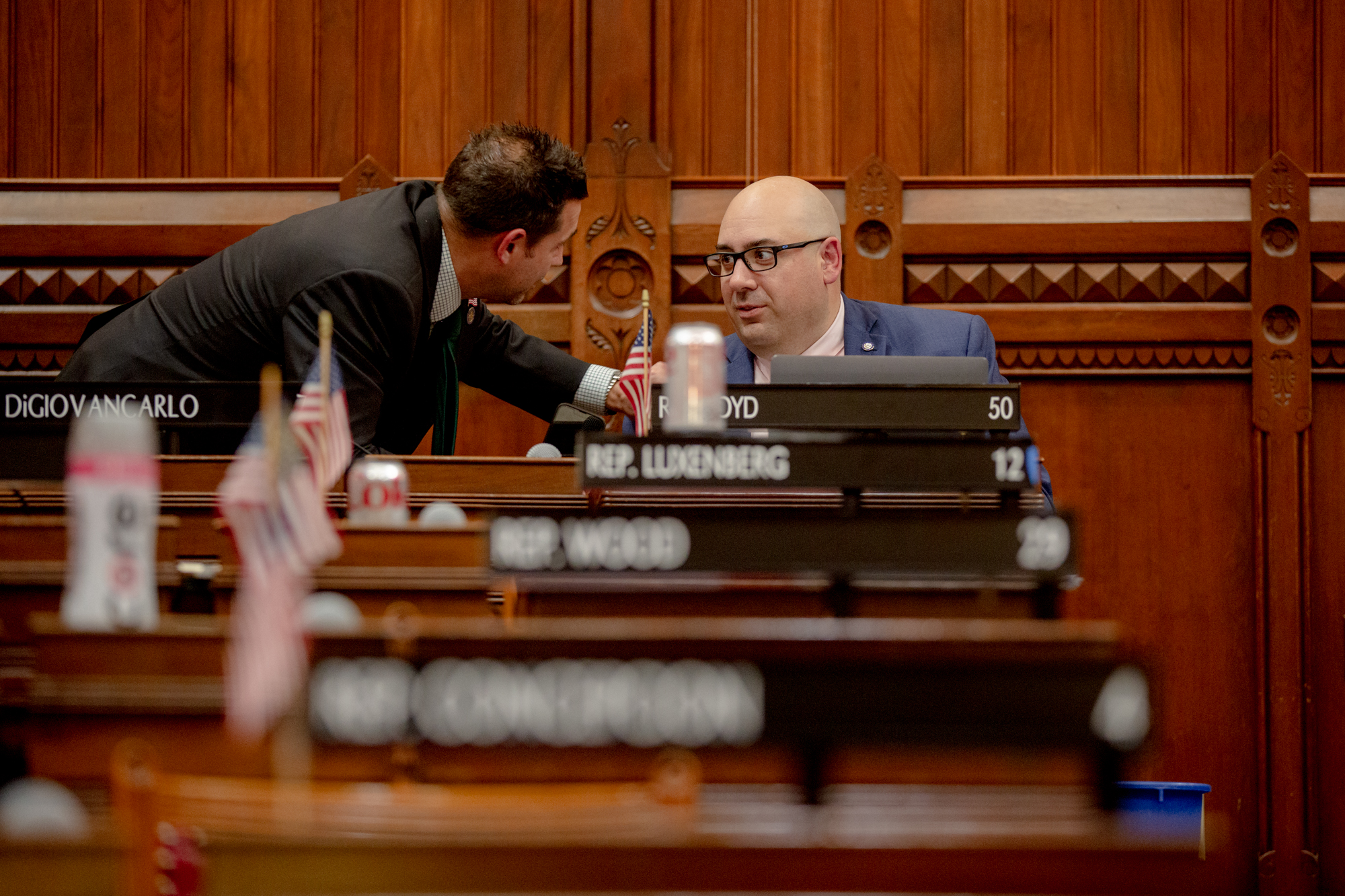 Rep. Pat Boyd is seen in the Connecticut House of Representatives chamber conversing with another legislator.