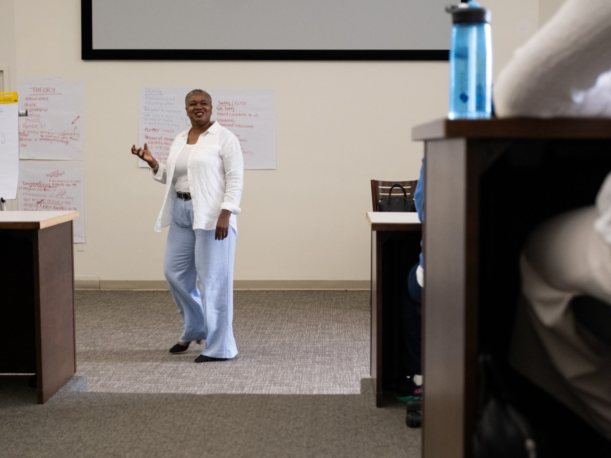 TaShun Bowden-Lewis, Connecticut's chief public defender, is standing at the front of a room, making a hand gesture, and talking to a group of people during a public defender training session.