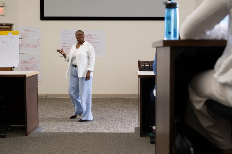 TaShun Bowden-Lewis, Connecticut's chief public defender, is standing at the front of a room, making a hand gesture, and talking to a group of people during a training session.