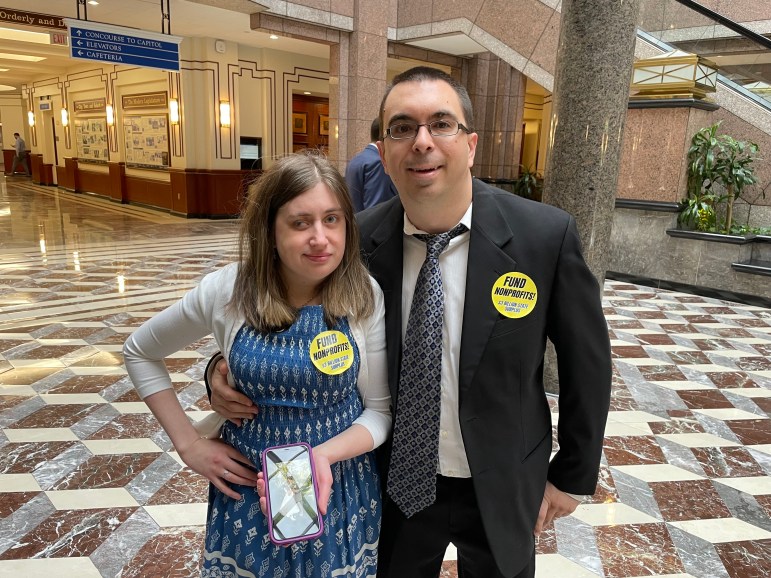 A man and woman at the Connecticut Capitol with stickers that say 'Fund Nonprofits!'