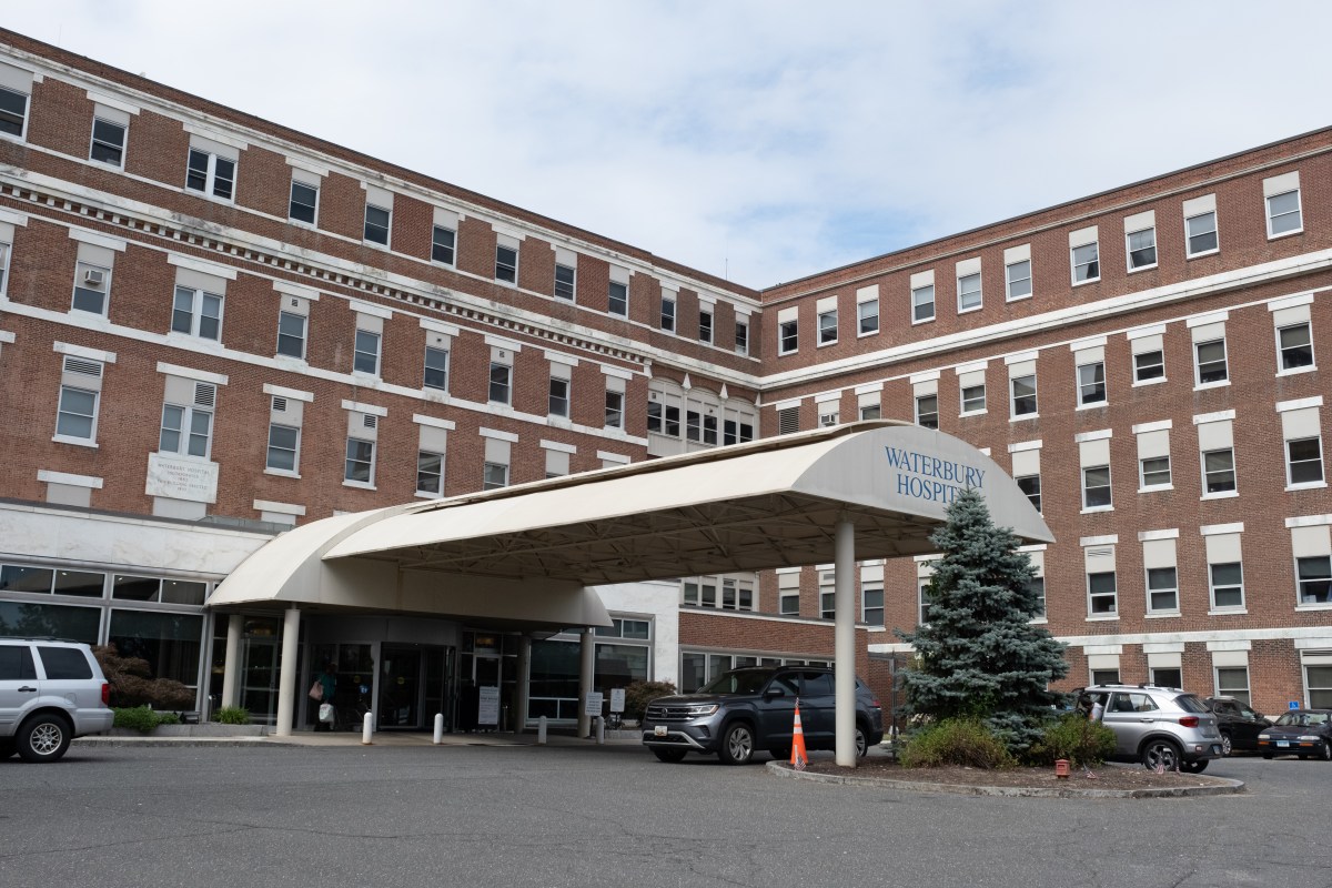The front of a large brown building with rows of windows and an awning over the entrance.