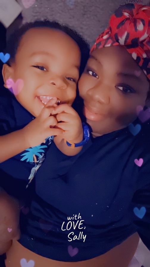 A mother and her toddler pose for a selfie. The photo has hearts around the edges and says "with Love, Sally"