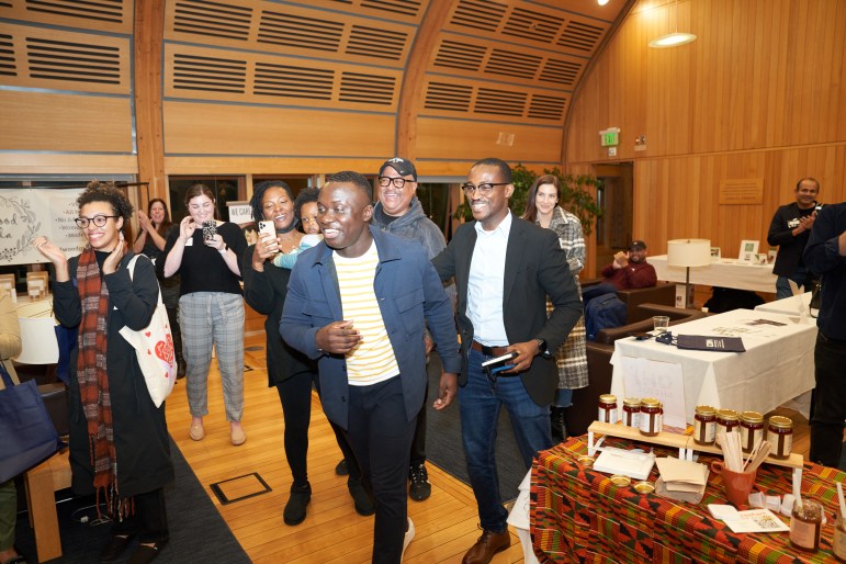People cheer as a man walks up to accept an award.