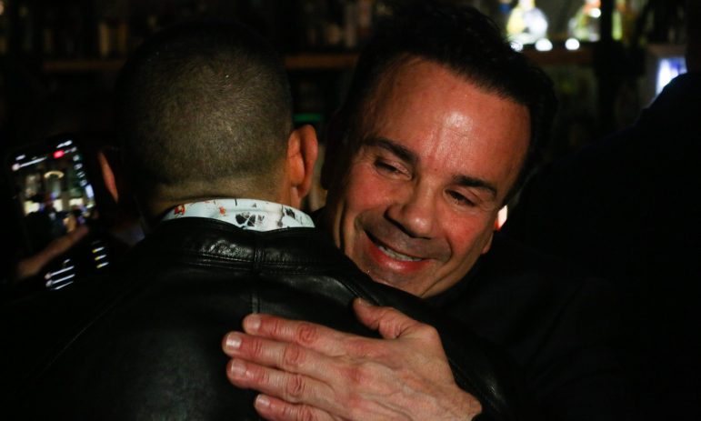 Joe Ganim is smiling while hugging and embracing a supporter.