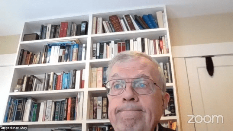 Judge Michael E. Shay is looking off into the distance, as seen via his computer camera during a legislative confirmation hearing.