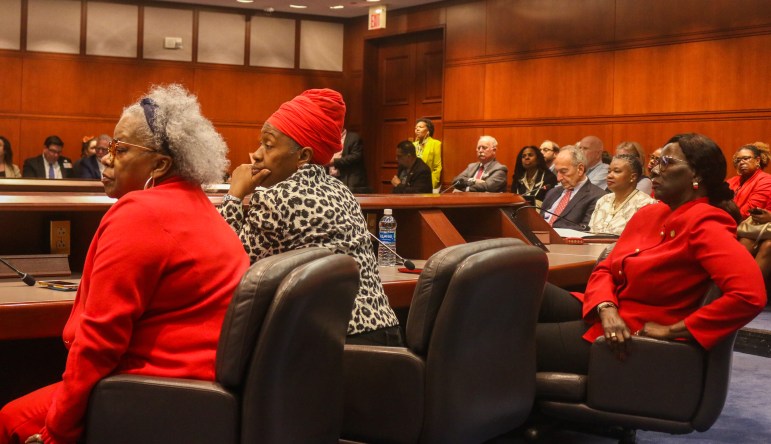 Sen. Marilyn Moore, Rep. Robyn Porter and Sen. Patricia Billie Miller are sitting next to each other and looking off into the distance at someone speaking.