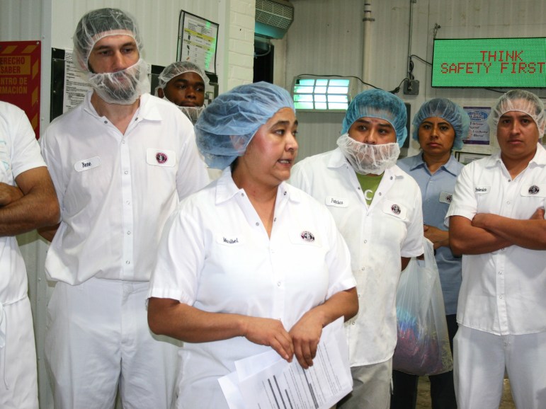 Bakery workers in hairnets and work shirts.
