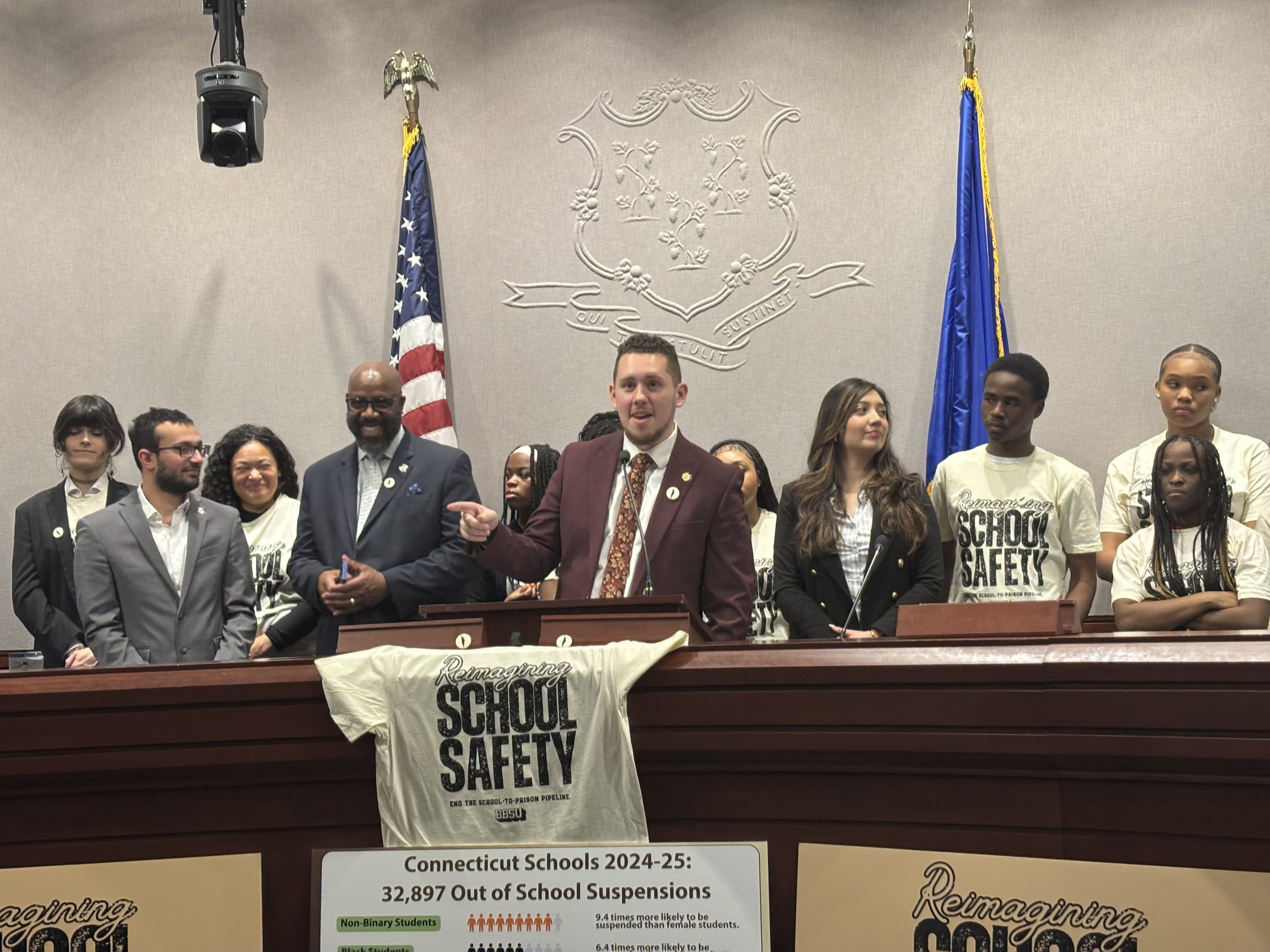 Rep. Antonio Felipe stands at a podium with several other people behind him.